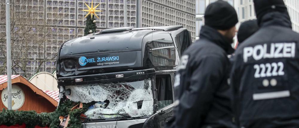 Polizisten stehen vor dem zerstörten LKW am Weihnachtsmarkt am Breitscheidplatz in Berlin. 