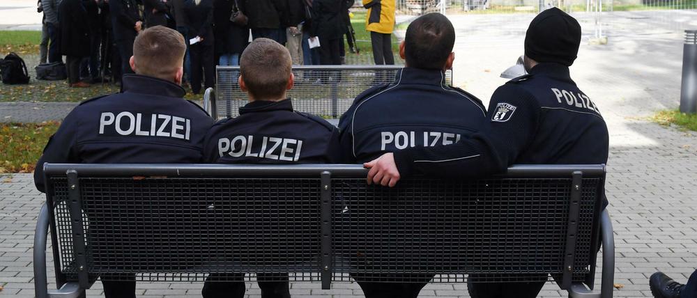 Polizeischüler sitzen am 03.11.2017 in Berlin in der Berliner Polizeiakademie auf einer Bank vor einem Ausbildungsgebäude.
