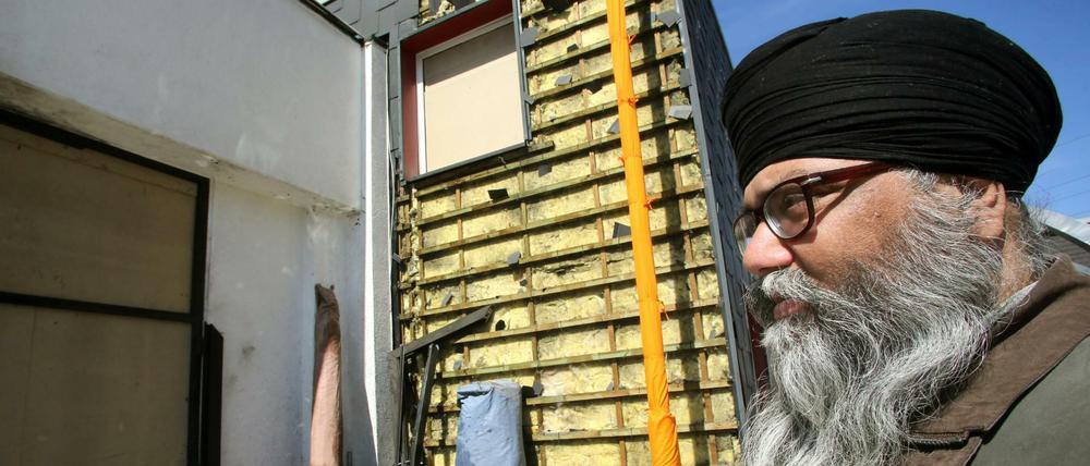 Joginer Singh, ein Prediger des Sikh-Gemeindezentrums, zeigt in Essen den zerstörten Eingangsbereich des Gebetshauses. Unbekannte hatten einen Sprengsatz zur Explosion gebracht.