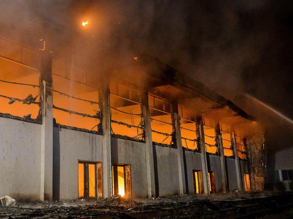 Nauen, August 2015: Eine Sporthalle, die als Notunterkunft für Flüchtlinge geplant war, geht in Flammen auf