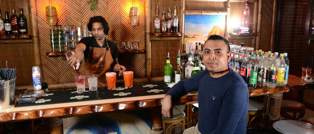 Barkeeper Shobus Reza mixt fruchtige Cocktails im „Zeitlos“. Unterm Bambusdach sollen Berliner die Sorgen vergessen.