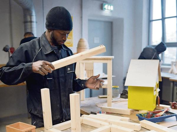 Ein junger Mann arbeitet in der Schreinerei der Flüchtlings-Initiative "Arrivo" der Handwerkskammer Berlin. 