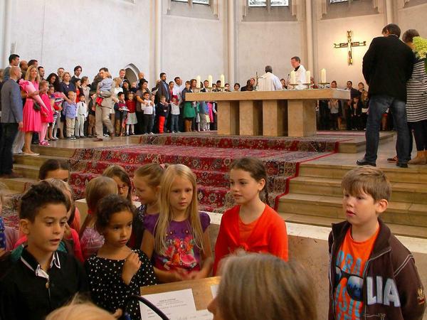 Die älteren Schüler singen, während sich die Schulanfänger zur Segnung um den Altar versammeln.