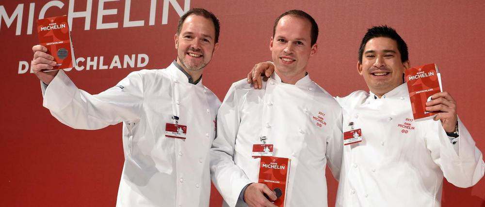 Die Chefköche Marco Müller aus Berlin, Tristan Brandt aus Mannheim und Tohru Nakamura aus München freuen sich bei der Präsentation des Restaurantführers Guide Michelin 2017 über ihre Auszeichnung mit dem zweiten Michelin Stern.