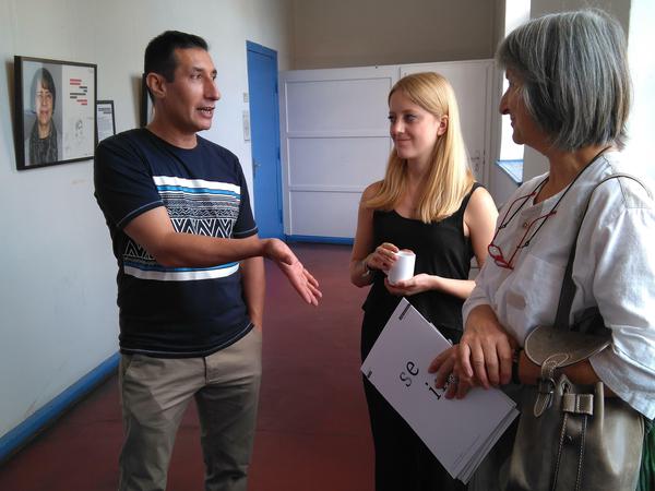 Hussein zeigt interessierten Besuchern die Ausstellung über engagierte Flüchtlinge in der Volkshochschule Ttreptow-Köpenick.