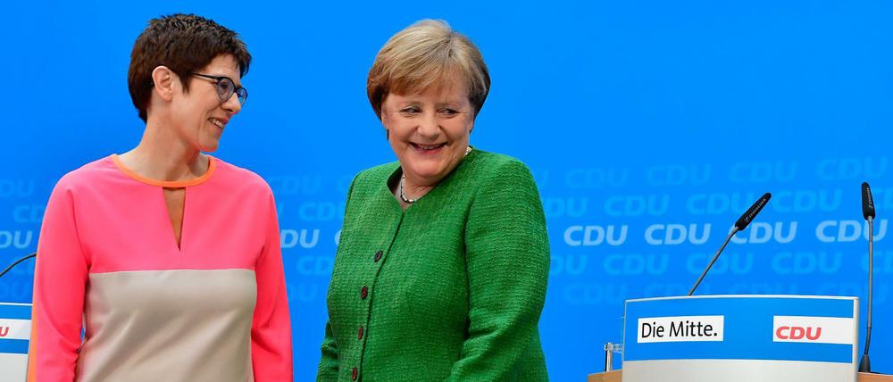Angela Merkel zeigt mit der neuen Generalsekretärin Annegret Kramp-Karrenbauer 