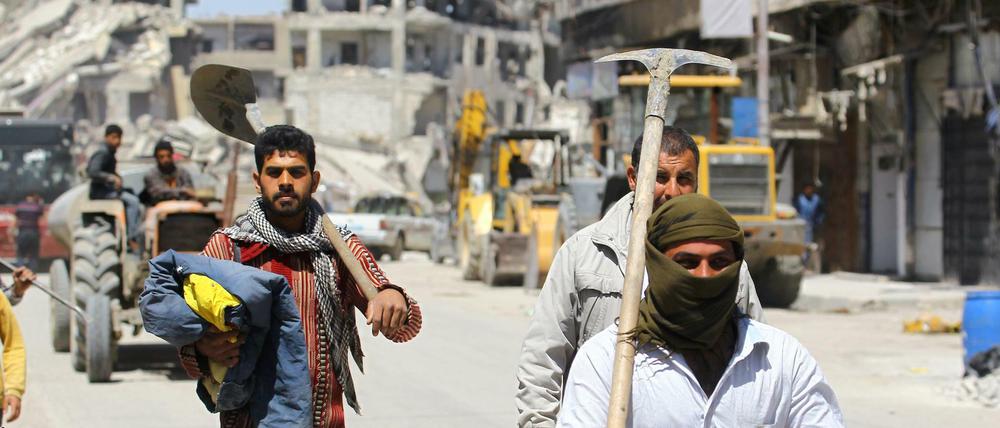 Aufbau in Syrien: Arbeiter mit Schaufeln in den Straßen von Rakka