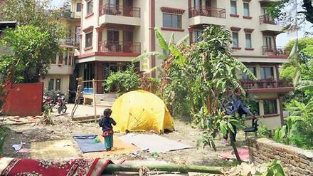 Dieses Hotelgebäude in Kathmandu steht noch. Es kann aber jeden Moment einstürzen. Deshalb wurde für Gäste ein Zelt aufgestellt. Ringsherum sind Mauern eingestürzt und der Boden ist aufgewühlt und brüchig. 