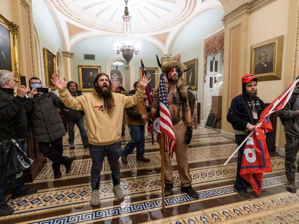 Unterstützer von US-Präsident Trump stehen vor Polizeien auf dem Gang vor der Senatskammer im Kapitol.