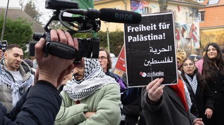 Ein Teilnehmer der propalästinensischen Kundgebung unter dem Motto „Solidarität mit Palästina“ vor der Mensa II an der Freien Universität (FU) hält ein Schild mit der Aufschrift „Freiheit für Palästina“ in der Hand. Die Uni hat Anzeige gegen eine Person der Demo sowie einen Teilnehmer der Gegendemo gestellt. 