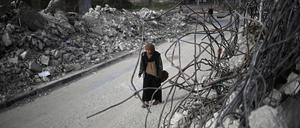 Eine Palästinenserin geht am 3. März 2024 in Rafah im südlichen Gazastreifen an den Trümmern von Häusern vorbei. 