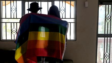 Ein Paar bedeckt sich mit einer Pride-Fahne. In Uganda hat das Verfassungsgericht ein umstrittenes Gesetz gegen Homosexuelle bestätigt.