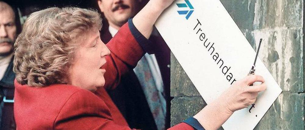 Weg damit. Die scheidende Treuhand-Präsidentin Birgit Breuel entfernt am 30. Dezember 1994 mit einem Schraubenzieher das Firmenschild am Eingang der Treuhandanstalt in Berlin-Mitte, dem heutigen Sitz des Bundesfinanzministeriums. 