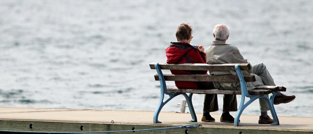 Ein Rentnerpaar genießt die Sonne auf einer Bank im Hafen am Cospudener See in Leipzig. 