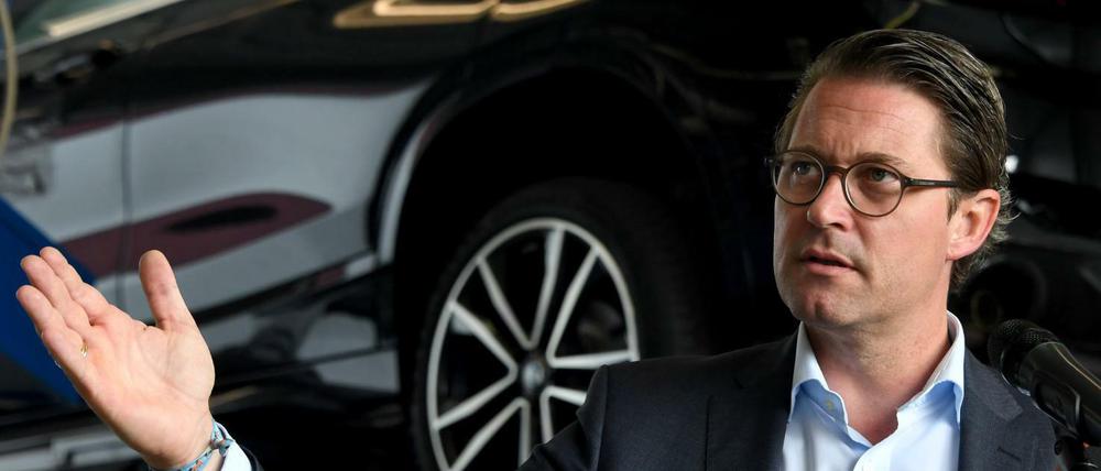 Verkehrsminister Andreas Scheuer (CSU) steht in einer Werkstatt vor einem Auto im Hauptabgaslabor des Kraftfahrt-Bundesamtes. 