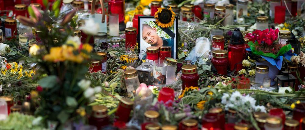 Ein Foto des Opfers steht am Tatort zwischen zahlreichen Blumen und Kerzen.