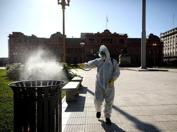 Ein Mann sprüht Desinfektionsmittel auf der Plaza de Mayo in Buenos Aires.