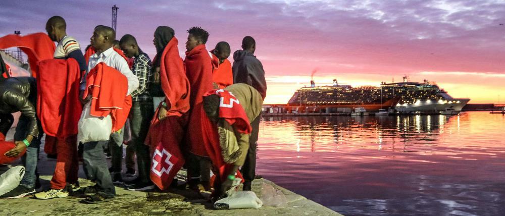 Einwanderer aus Nordafrika stehen am Hafen von Malaga. 