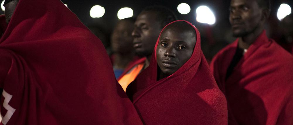 In Decken gehüllte afrikanische Flüchtlinge warten in Motril darauf, vom Roten Kreuz registriert zu werden.