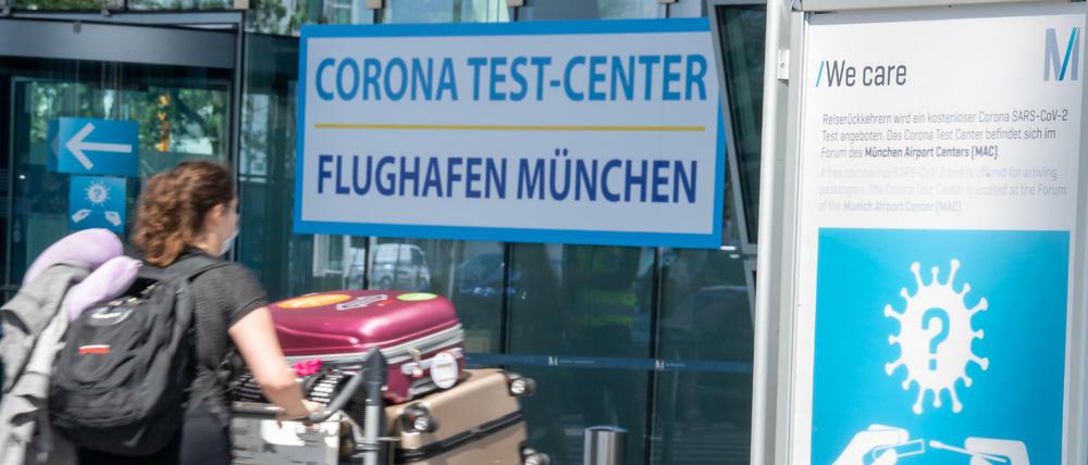 Eine Reisende gehen zum Testzentrum am Münchner Flughafen.