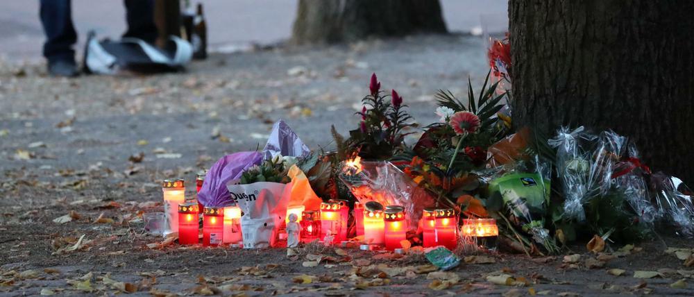 Ein Teilnehmer einer Kundgebung für einen verstorbenen 22-Jährigen sitzt auf einem Spielplatz neben Kerzen und Blumen. 