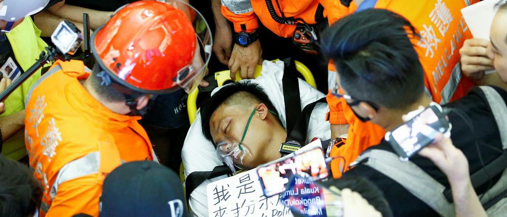 Einer der von Demonstranten angegriffenen Männern am Hongkonger Flughafen wird versorgt.
