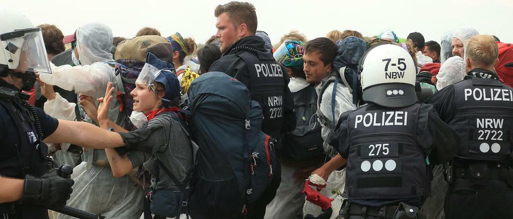 Polizisten versuchen, die Klimaschützer daran zu hindern, in den Tagebau Garzweiler einzudringen.