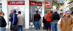 Zyprische Bankkunden stehen an einer geschlossenen Bank an. Es ist unklar, wie es weitergeht auf der Insel. 