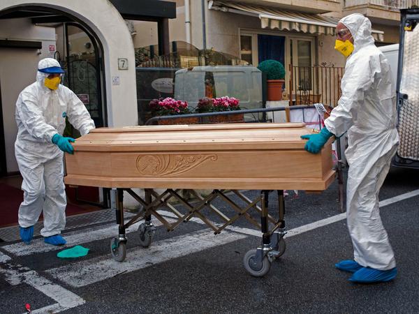 Medizinisches Personal in Schutzanzügen trägt einen Sarg mit dem Leichnam einer 87-jährigen Frau aus einem Hotel, nachdem sie in ihrem Zimmer verstorben ist. Die Frau, die zu einer Gruppe älterer Touristen aus der Region Lombardei gehörte, wurde positiv auf das Coronavirus getestet. Das Hotel wurde unter Quarantäne gestellt.