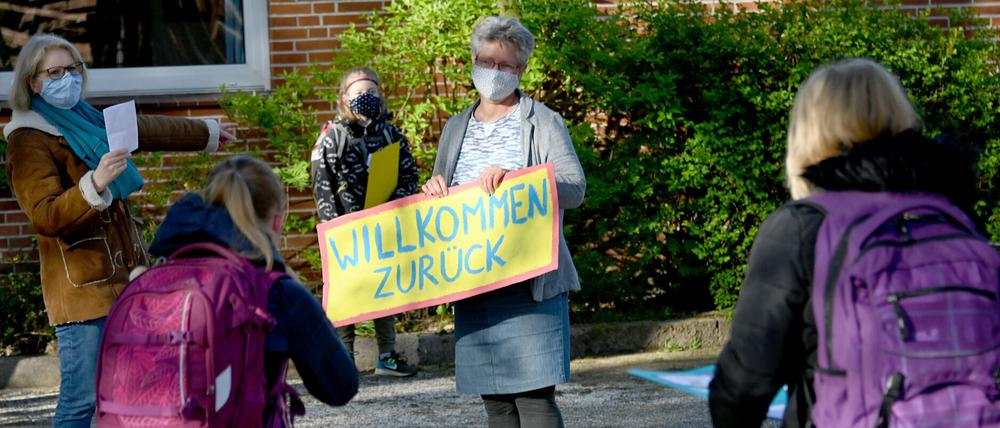 Eine Lehrerin begrüßt einer Grundschule in Schleswig-Holstein begrüßt ihre Schüler. Hier wurden die Schulen für die 4. Klassen an Grundschulen wieder geöffnet. 