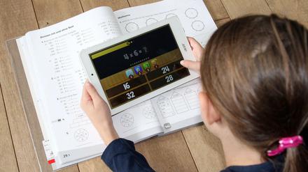 Eine Schülerin arbeitet zu Hause an ihrem Tablet mit einer Lern-App.