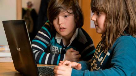 Ein Geschwisterpaar lernt Zuhause - am Laptop.