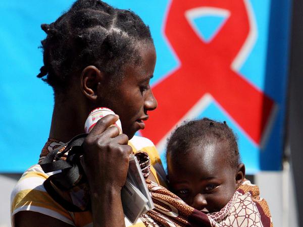 Mutter mit Kind vor einem HIV-Aufklärungsplakat nahe Johannesburg, Südafrika. Afrika südlich der Sahara ist die Weltregion mit den meisten HIV-Infizierten und den größten Problemen bei Therapie in Prävention. (Archivbild 31 Juli 2008).